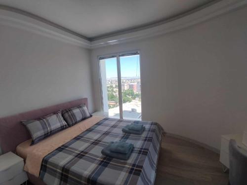 a bedroom with a bed with two pillows and a window at Skopje Sky Apartments & Floor 33th 28th & 25th & 19th & 13th 12th With Pool & Spa & Fitness & Parking Included in Price in Skopje