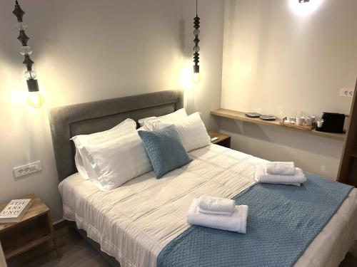 a bedroom with a bed with towels on it at Casa di Lou in Ermoupoli