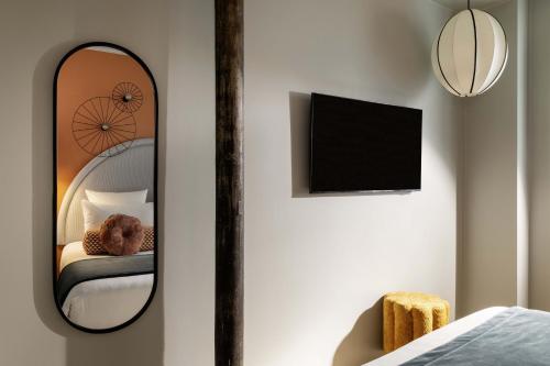 a mirror in a bedroom with a teddy bear on a bed at LE CLARK HOTEL in Paris
