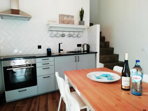 a kitchen with a wooden table with a bottle of wine at Sunset Little House in Aljezur