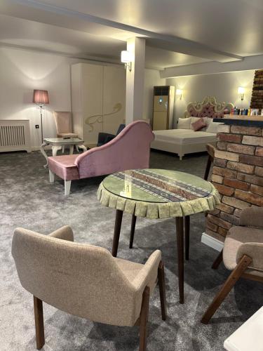 a living room with couches and a table and chairs at Maajid Boutique Hotel in Baku