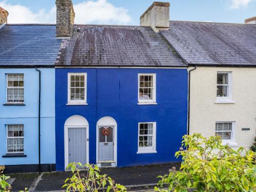 a blue house with white windows and a roof at Number 4 in Llandeilo