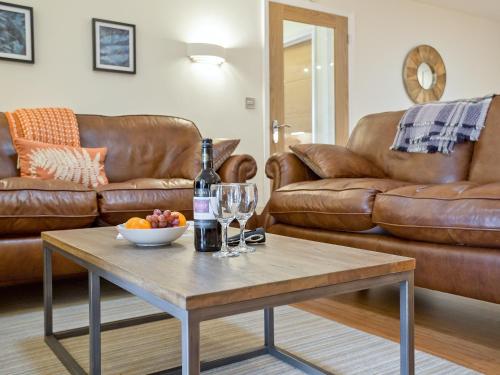a living room with a table with a bottle of wine and glasses at The Bunker in Sennen