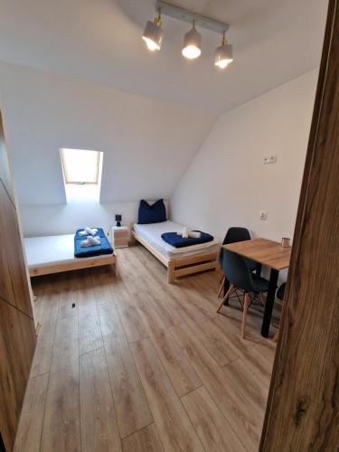 a room with two beds and a table at PokojeNaSpacerowej in Gąski