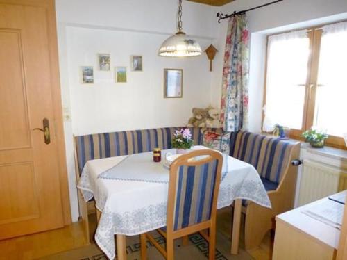 a dining room with a table and chairs and a window at Fewo Bärli in Bayersoien