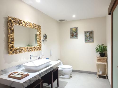 a bathroom with a sink and a mirror on the wall at Rama Residence Petitenget in Seminyak