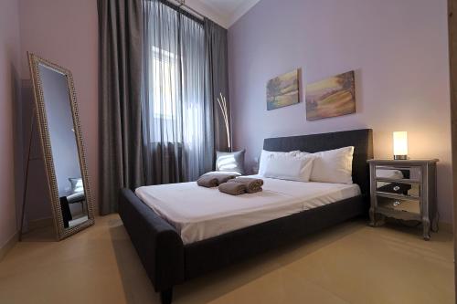 une chambre avec un grand lit et un miroir dans l'établissement Brand New 2 Bed Sliema Apt, à Sliema