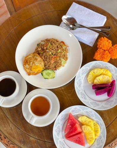 a table with plates of food and cups of coffee at Pondok BIMA in Tegalalang