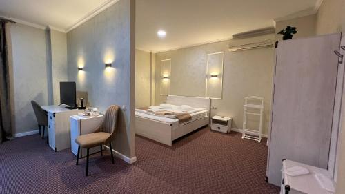 a hotel room with a bed and a desk and a chair at JEPPESEN RESIDENCE in Almaty