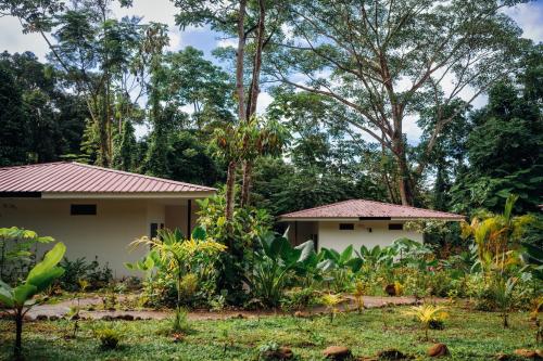two houses in a garden with trees in the background at Taki Tambo Lodge in Tarapoto