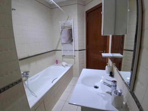 a white bathroom with a tub and a sink at Lake 2 Luxurious 1 bedroom apartment in Tunis