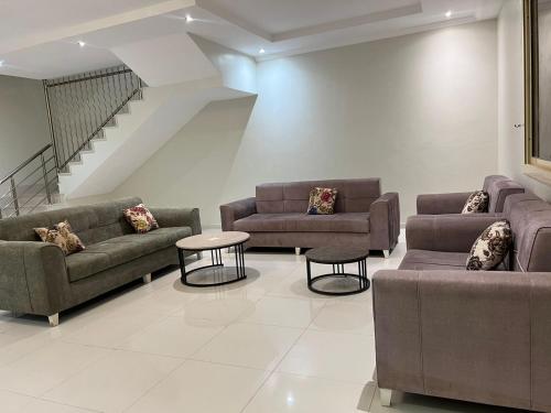a living room with couches and tables and a staircase at الصواري ريزدينس in Jeddah