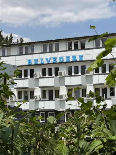 ein weißes Gebäude mit einem blauen Schild darauf in der Unterkunft Belvedere Costinesti in Costinești