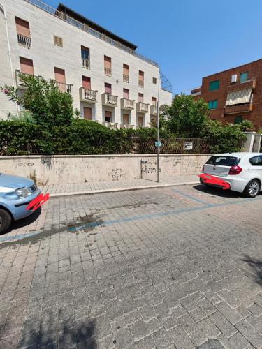two cars parked in a parking lot next to a building at Oltremare FRONTE SPIAGGIA in Ladispoli