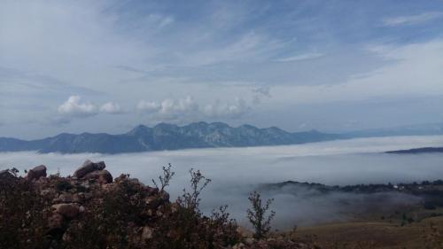 a view of a foggy valley with mountains in the background at Seoski dom in Šavnik