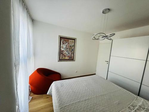 Un dormitorio con una cama y una silla roja. en Charming Apartment Mari Žnjan, en Split