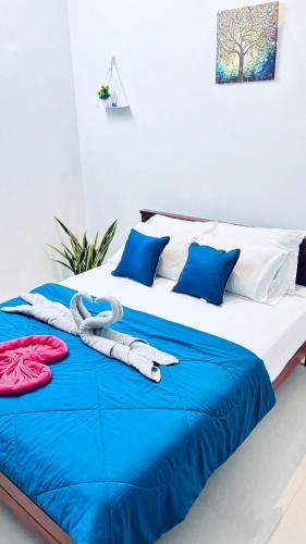 a bed with blue and white sheets and blue pillows at Hermanos Hideaway in Varkala