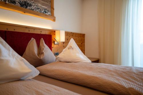a bedroom with two beds with pillows on them at Hotel Garni Savoy - new opening in Castelrotto