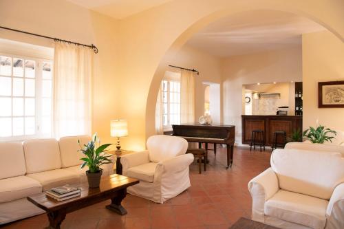 a living room with white furniture and a piano at Luna Sardinia in Santa Margherita di Pula