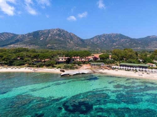 an aerial view of a beach with mountains in the background at Luna Sardinia in Santa Margherita di Pula