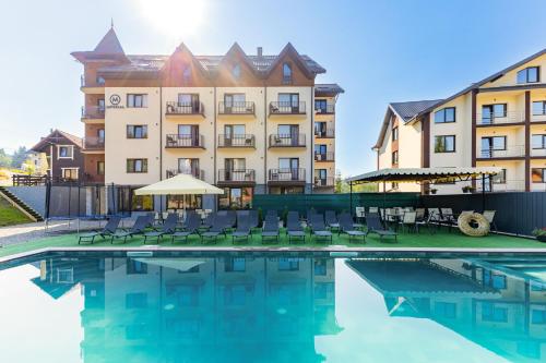 a hotel with a pool in front of a building at Imperial Hotel in Bukovel