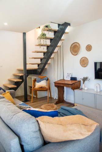 a living room with a blue couch and stairs at Gites du réservoir in Mauguio