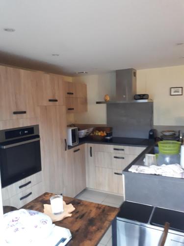 une cuisine avec des armoires en bois et un comptoir dans l'établissement La Dolce Vita, à Montchanin