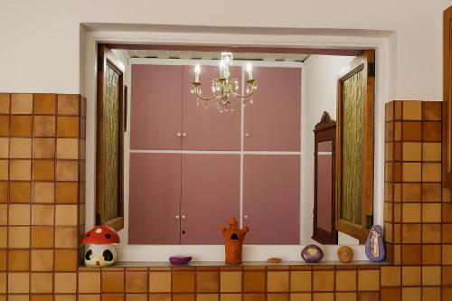a window in a kitchen with a chandelier at Mponanos' Family House in Ágios Matthaíos