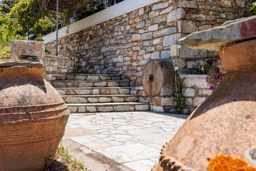 a stone wall with stairs and vases in front at Villa Mitsa in Kolios
