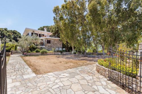 a stone driveway with a fence in front of a house at Villa Mitsa in Kolios