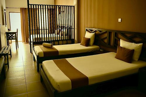 a hotel room with two beds and a chair at La suite by Aren'Ala - Résidence Volavita in Antsirabe