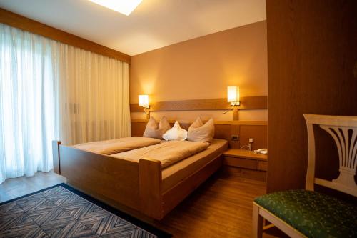 a bedroom with a large bed in a room at Hotel Garni Savoy - new opening in Castelrotto