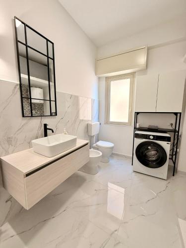 een badkamer met wastafel en wasmachine bij La casa delle parole 2 in Agrigento