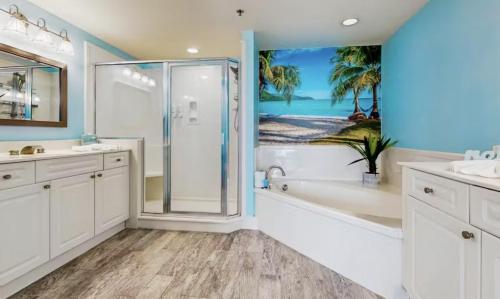 a bathroom with a shower and two sinks and a bathtub at Gulf-Front Waterscape B401 Sundrenched in Fort Walton Beach