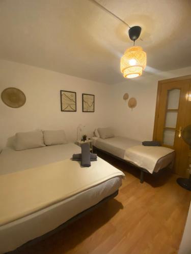 a bedroom with two beds and a chandelier at Plaza Guest House in Madrid