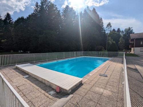 une piscine dans une cour clôturée dans l'établissement Appartement 4-6 Personnes - Piscines - SAMOENS - HAUTE SAVOIE, à Samoëns