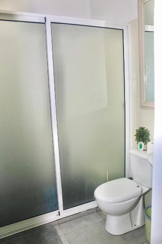 a bathroom with a toilet and a glass shower at Hotel Pousada Venus in São Filipe