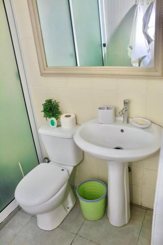 a bathroom with a sink and a toilet and a mirror at Hotel Pousada Venus in São Filipe