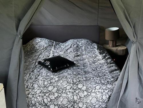 a bed in a tent with a pillow on it at De Drentse Safari in Sleen