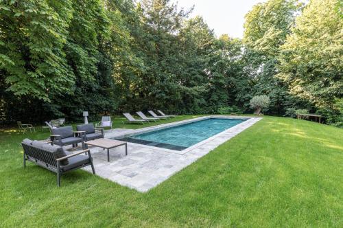 - une piscine dans une cour avec des chaises et une table dans l'établissement VILLA MEGUINELLE, à Grand-Fougeray