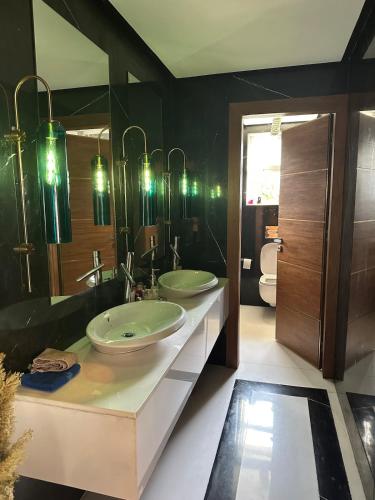 a bathroom with two sinks and a large mirror at 1700sqm Unique Villa in Bouskoura in Bouskoura