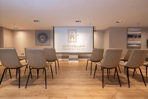 a conference room with chairs and a projection screen at Grand day in Al Hofuf