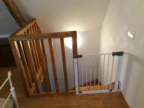 a wooden staircase with a wooden railing in a room at Gîtes Oasis du Lot in Payrac