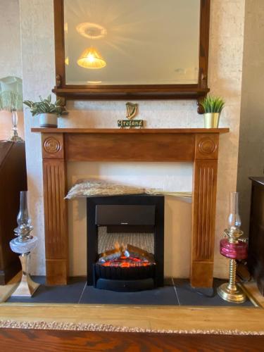 a fireplace in a living room with a mirror at Cosy Authentic Home in Belfast