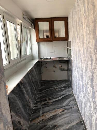 a kitchen with a marble floor and two windows at Kirayə ev in Mekhrably