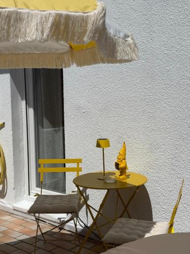 a table and two chairs and a table with a lamp at Gites du réservoir in Mauguio
