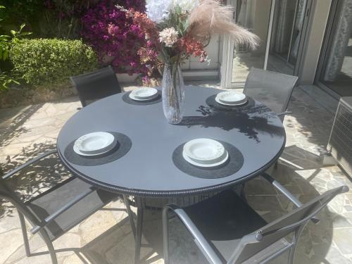 une table bleue avec des chaises et un vase de fleurs dans l'établissement Mathéo, à Cannes
