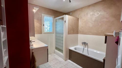 マロセーヌにあるLa Villa St Rochの浴槽と洗面台のあるバスルーム