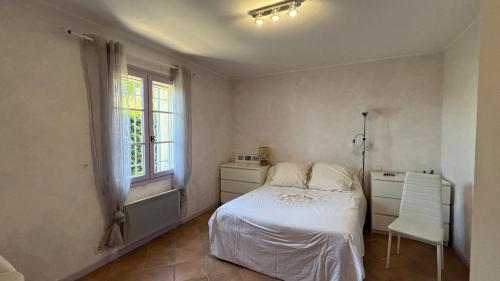 マロセーヌにあるLa Villa St Rochのベッドルーム1室(ベッド1台、窓、椅子付)
