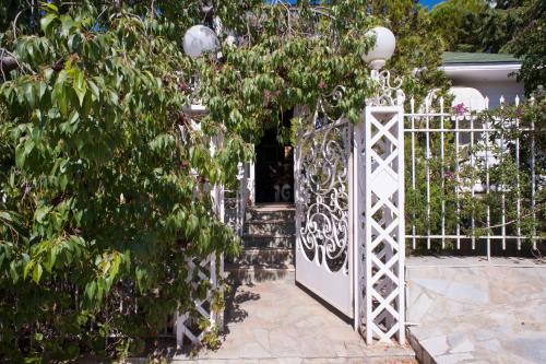 a white gate in front of a garden at Villa Lagonisi, magnificent Villa in the Athenian Riviera in Áyios Nikólaos